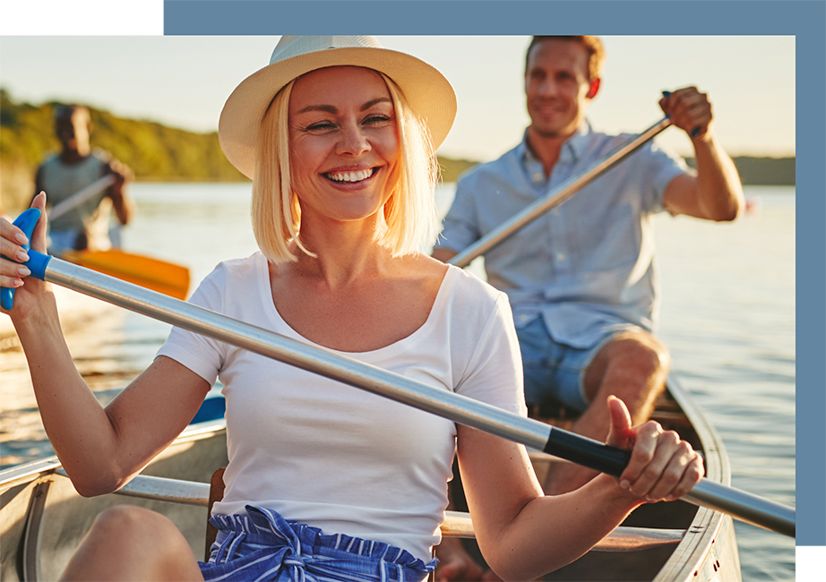 Man and woman rowing a canoe smiling and having fun feeling healthy