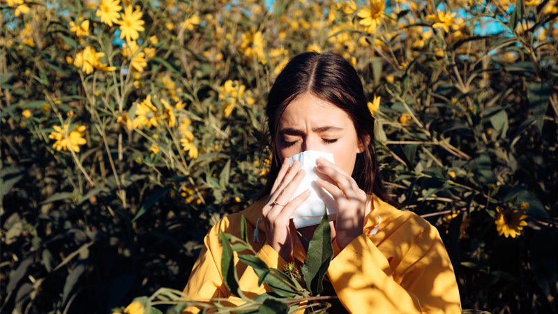woman sneezing in flower field